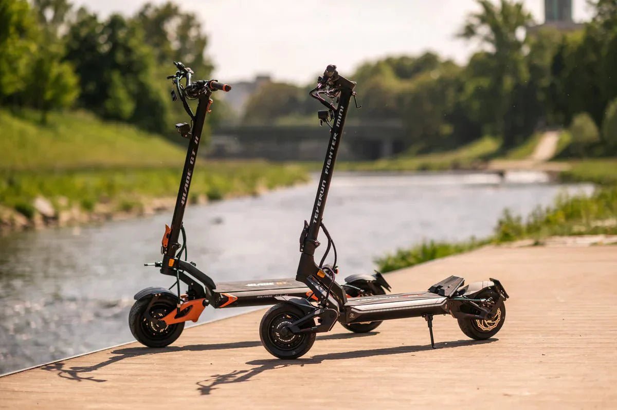 Teverun Blade GT II och Fighter Mini parkerade bredvid varandra på en träbrygga vid en å, med grönska i bakgrunden