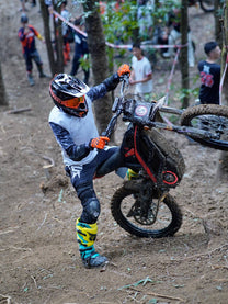 Förare gör ett hopp med 79BIKE Falcon Pro el-cross i skogen