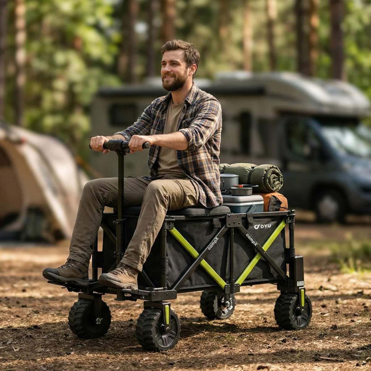 Man sitter på DYU Campx med packning på en campingplats i skogen, husbil och tält i bakgrunden