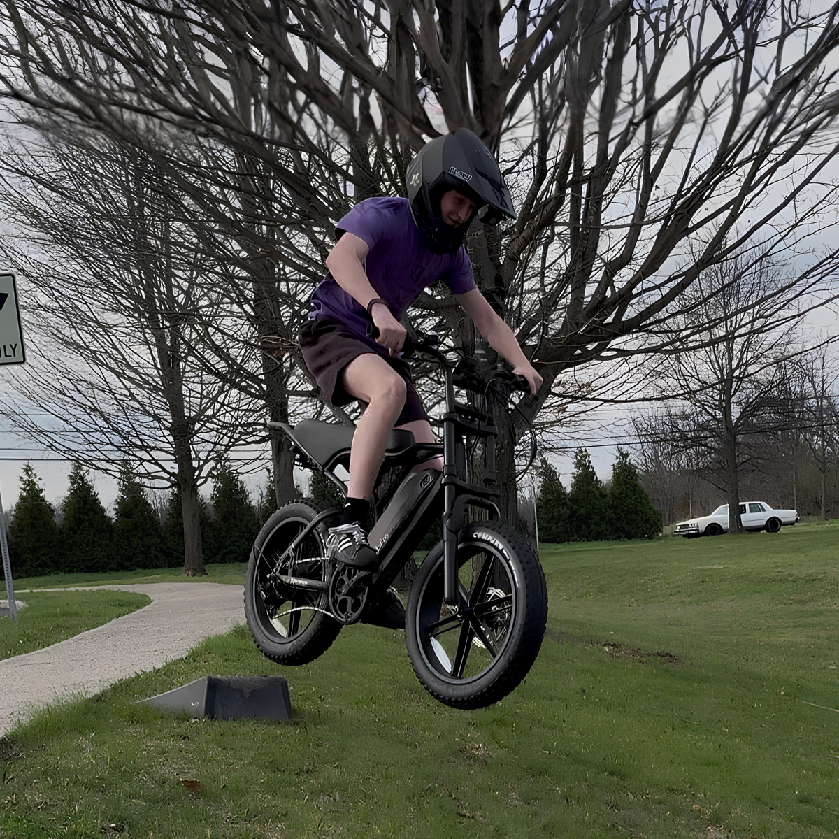 Förare gör ett hopp med TST R002 Plus fatbike-elcykel i färgen svart i en park