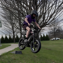 Förare gör ett hopp med TST R002 Plus fatbike-elcykel i färgen svart i en park
