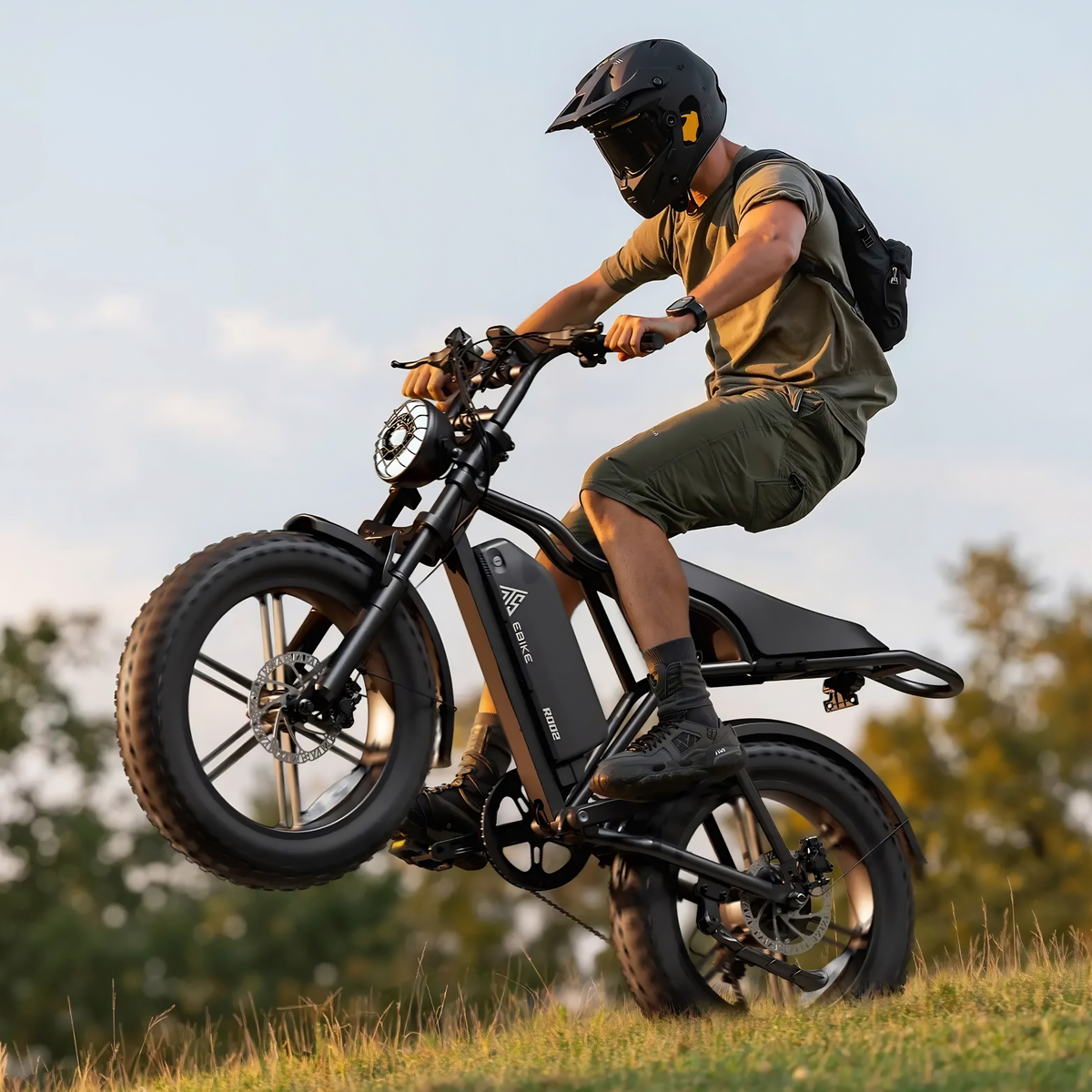 Förare gör ett hopp med TST R002 Plus fatbike-elcykel i färgen svart på en gräsplan