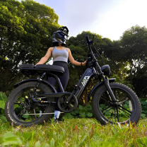 Kvinna som kör TST R7 fatbike-elcykel i färgen svart på en gräsplan