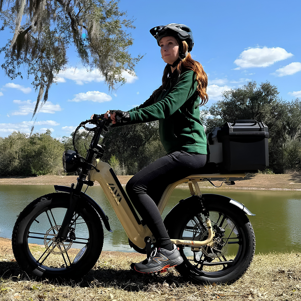 Kvinna som kör TST R7 fatbike-elcykel i färgen beige vid en sjö