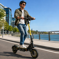 Man med hjälm åker Wheely - H7 elscooter längs en kaj vid vattnet