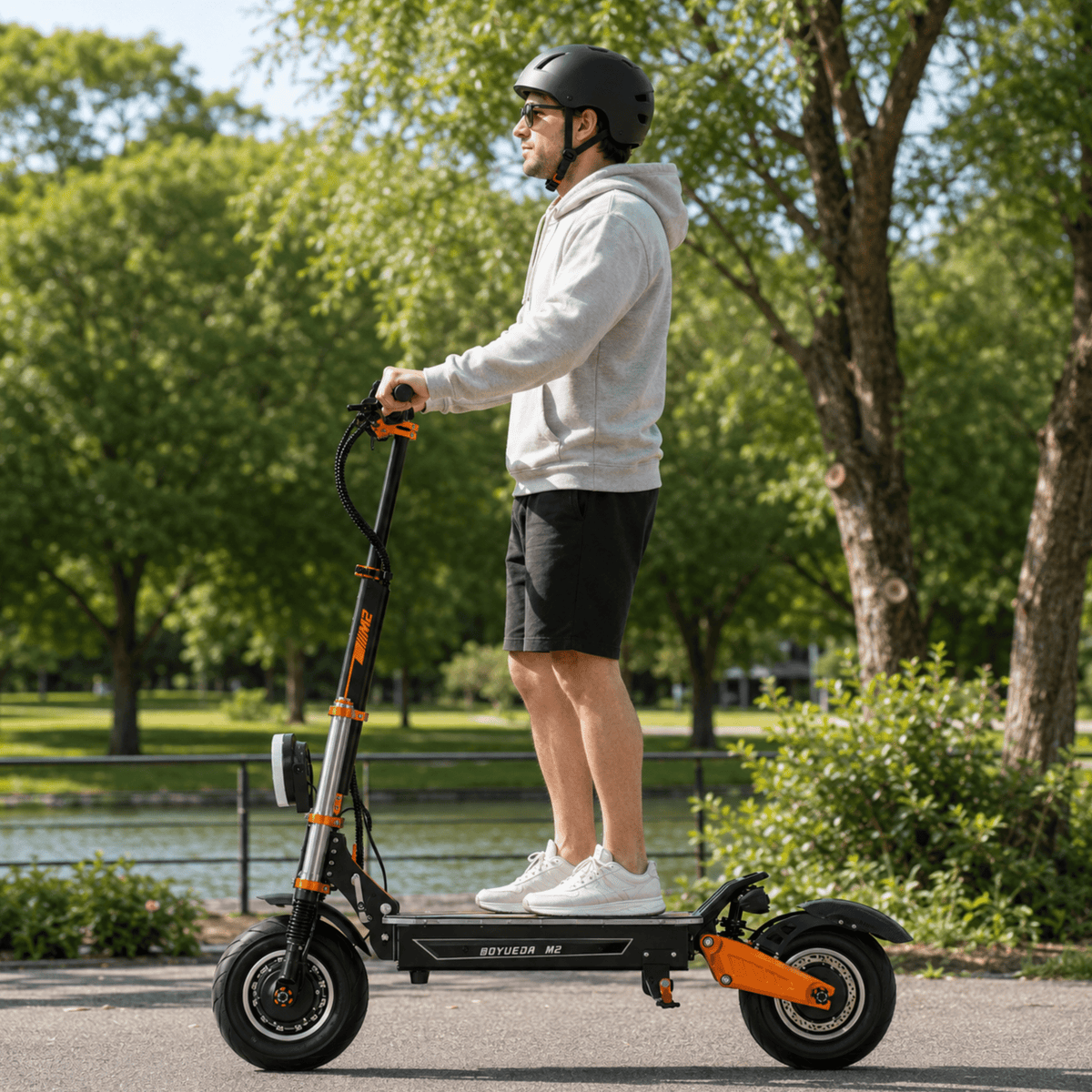 Man står med BOYUEDA M2 elsparkcykel i en park