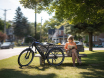 Person sitter bredvid Duotts C29 Max elcykel i en park