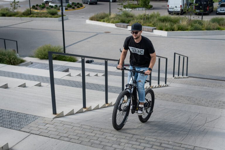 Man som kör Duotts E29 elmountainbike på en gångväg