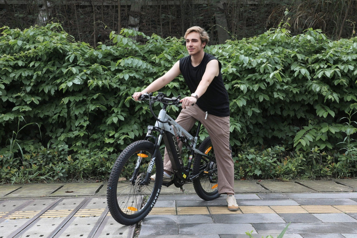 Kvinna står med Duotts E29 elmountainbike i en park