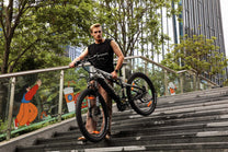 Kvinna står med Duotts E29 elmountainbike i en park