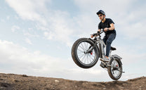 Förare gör ett hopp med Duotts F26 Lite fatbike-elcykel