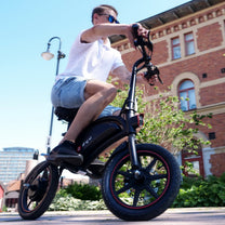 Man som kör DYU D3S hopfällbar elcykel i stadsmiljö
