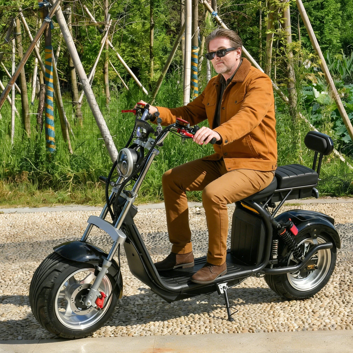 Man sitter på eHoodax X10 City Road elsparkcykel på en grusväg