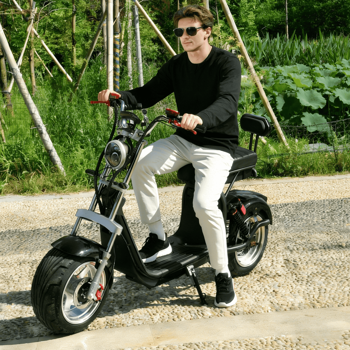 Man som kör eHoodax X10 City Road elsparkcykel på en grusväg