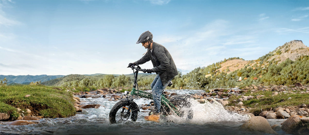Man som kör ENGWE EP-2 3.0 Boost hopfällbar fatbike-elcykel på en gräsplan