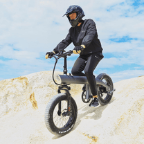 Man som kör HX Q3 Plus fatbike-elcykel i sandig terräng