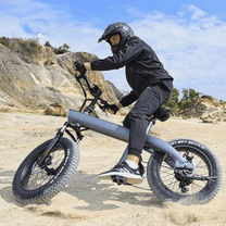 Man som kör HX Q3 Plus fatbike-elcykel i sandig terräng