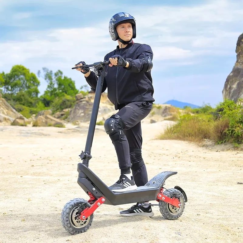 Man som kör HX X10 elsparkcykel i sandig terräng