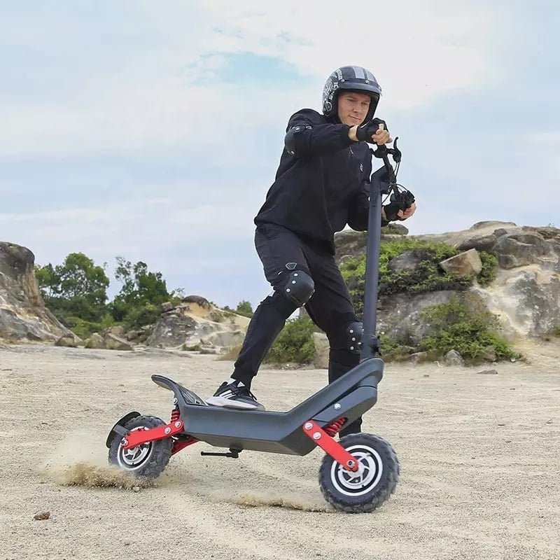 Man som kör HX X10 elsparkcykel i sandig terräng