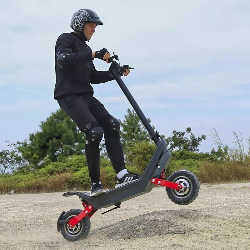 Man som kör HX X10 elsparkcykel i sandig terräng