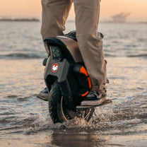 Person som kör InMotion V12S elektrisk enhjuling vid havet