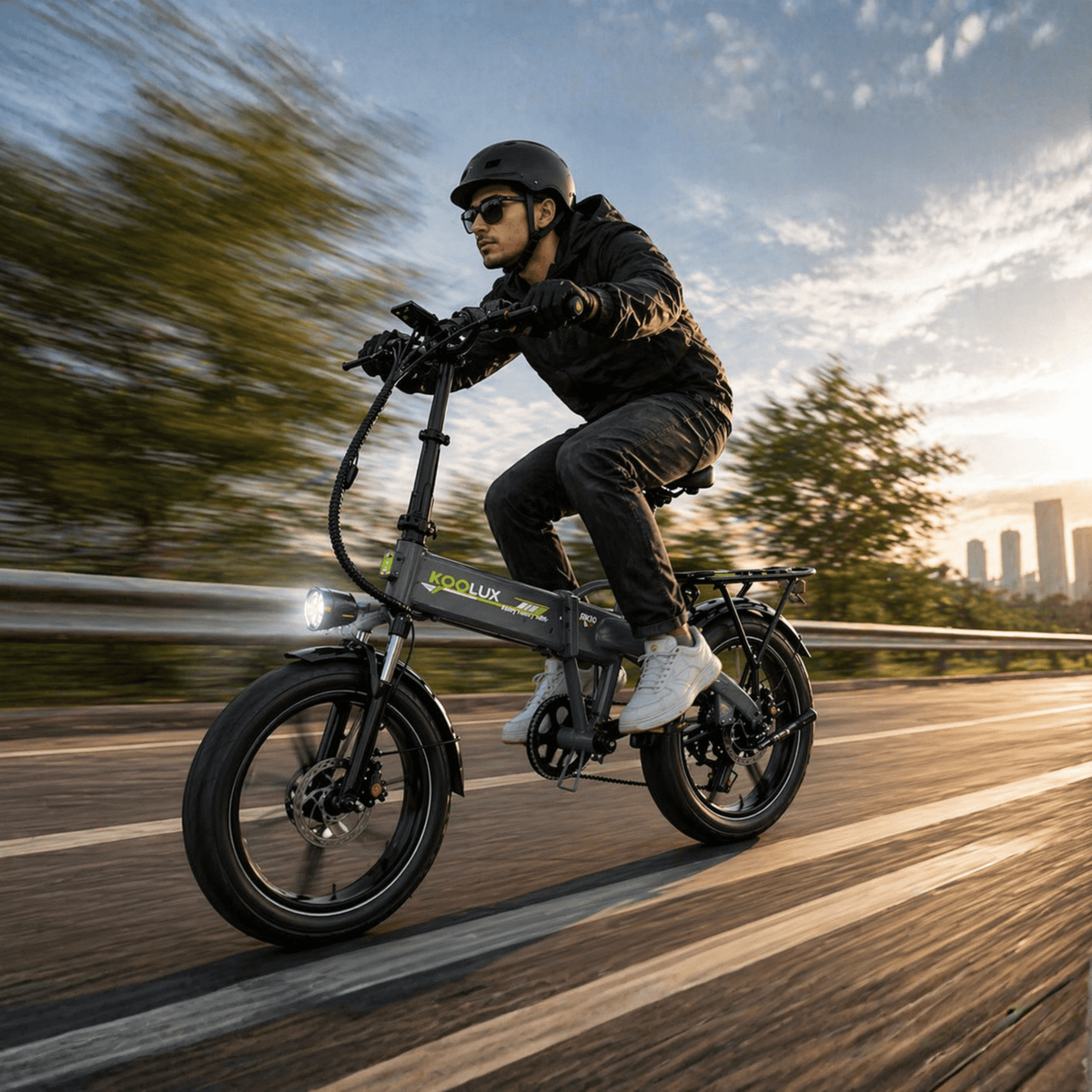 Man som kör KOOLUX RK10 hopfällbar fatbike-elcykel på en väg i solnedgång
