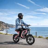Person som kör KOOLUX X9 Mini fatbike-elcykel vid havet