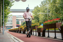 Man som kör KuKirin G2 VMP elsparkcykel i stadsmiljö