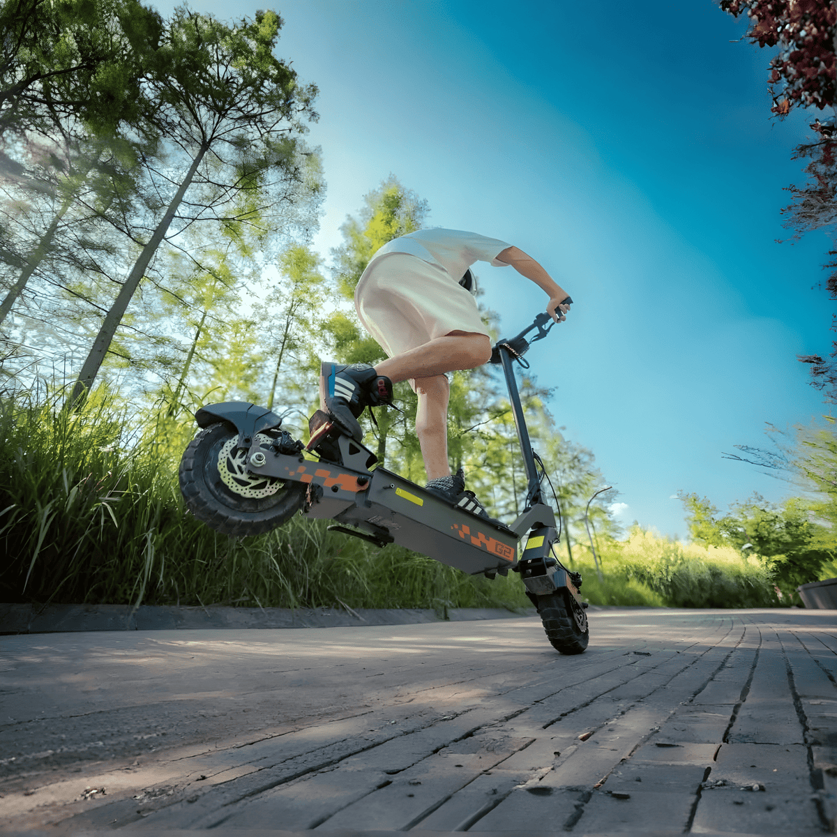 Förare gör ett hopp med KuKirin G2 VMP elsparkcykel på en väg