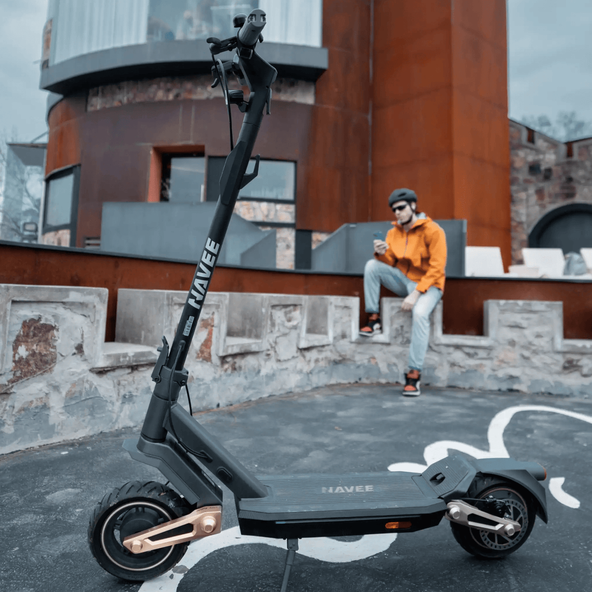 Person står med NAVEE ST3 elsparkcykel