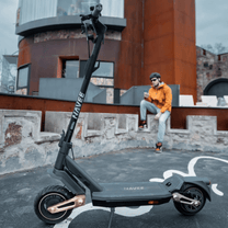 Person står med NAVEE ST3 elsparkcykel