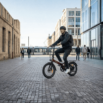 Man som kör Onemile E2 hopfällbar elcykel på en gata