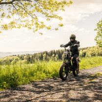 Man som kör Onemile M40 PRO fatbike-elcykel på en gångväg
