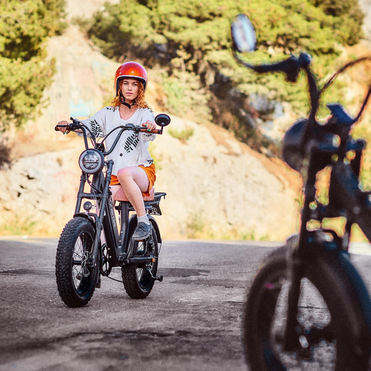 Kvinna som kör Onemile M40 PRO fatbike-elcykel med hjälm