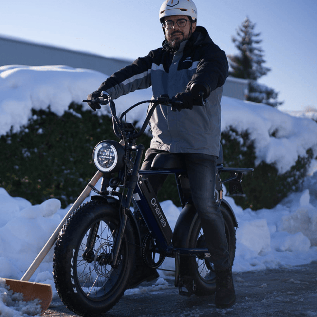 Man står med Onemile P40 Pro fatbike-elcykel i snö