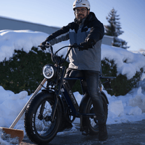 Man står med Onemile P40 Pro fatbike-elcykel i snö