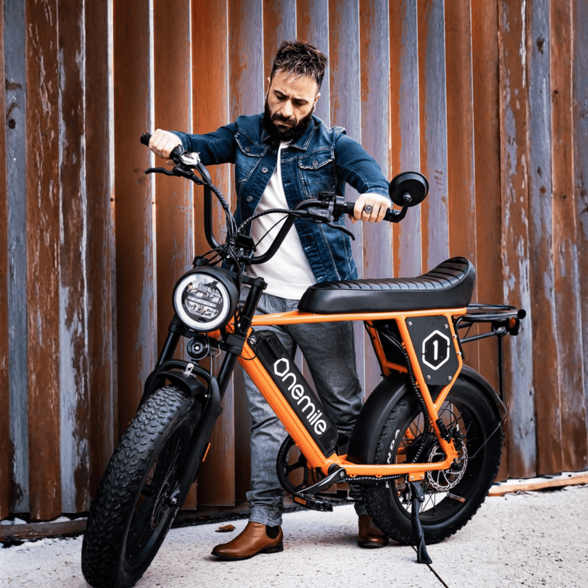 Man står med Onemile P40 Pro fatbike-elcykel i färgen orange