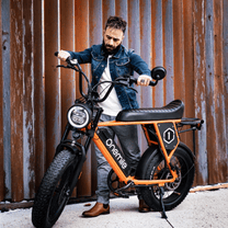 Man står med Onemile P40 Pro fatbike-elcykel i färgen orange
