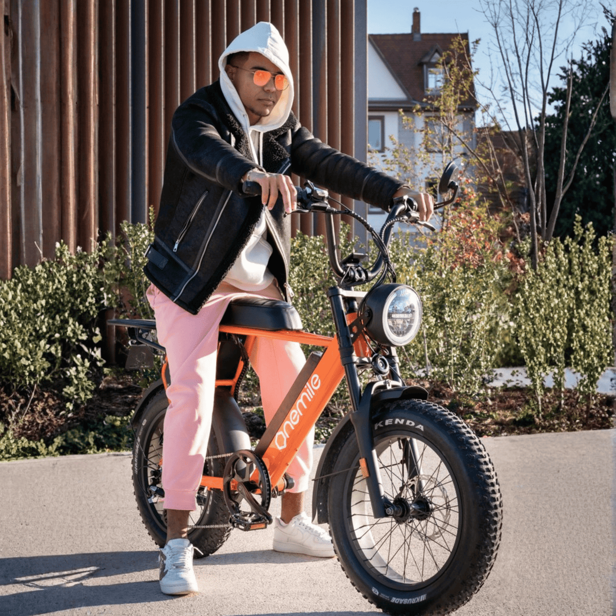 Person står med Onemile P40 Pro fatbike-elcykel på en gata