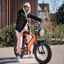 Person står med Onemile P40 Pro fatbike-elcykel på en gata