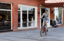 Kvinna som kör OneSport OT02 hopfällbar elcykel på en gata