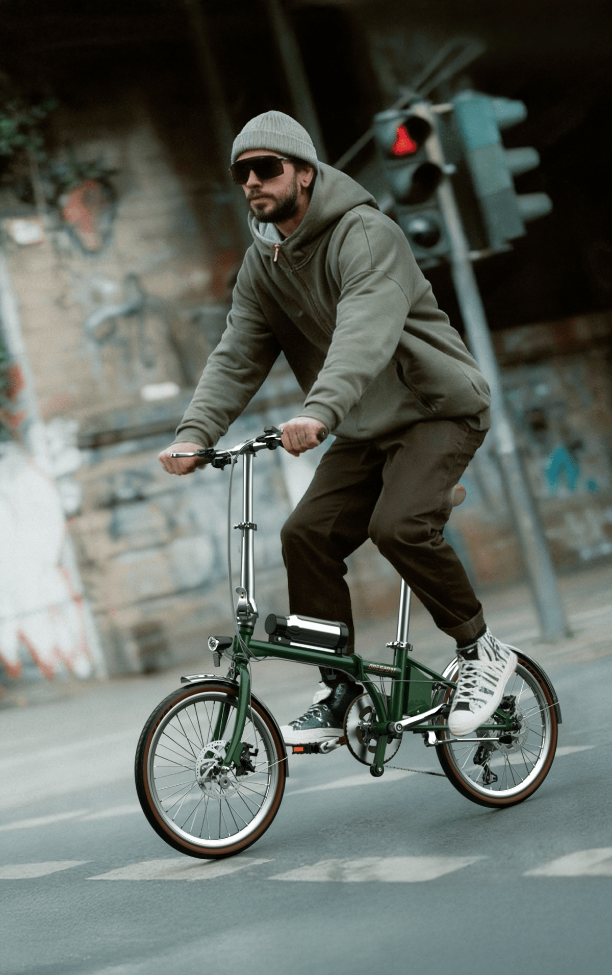 Man som kör OneSport OT02 Pro hopfällbar elcykel i färgen grön på en gata