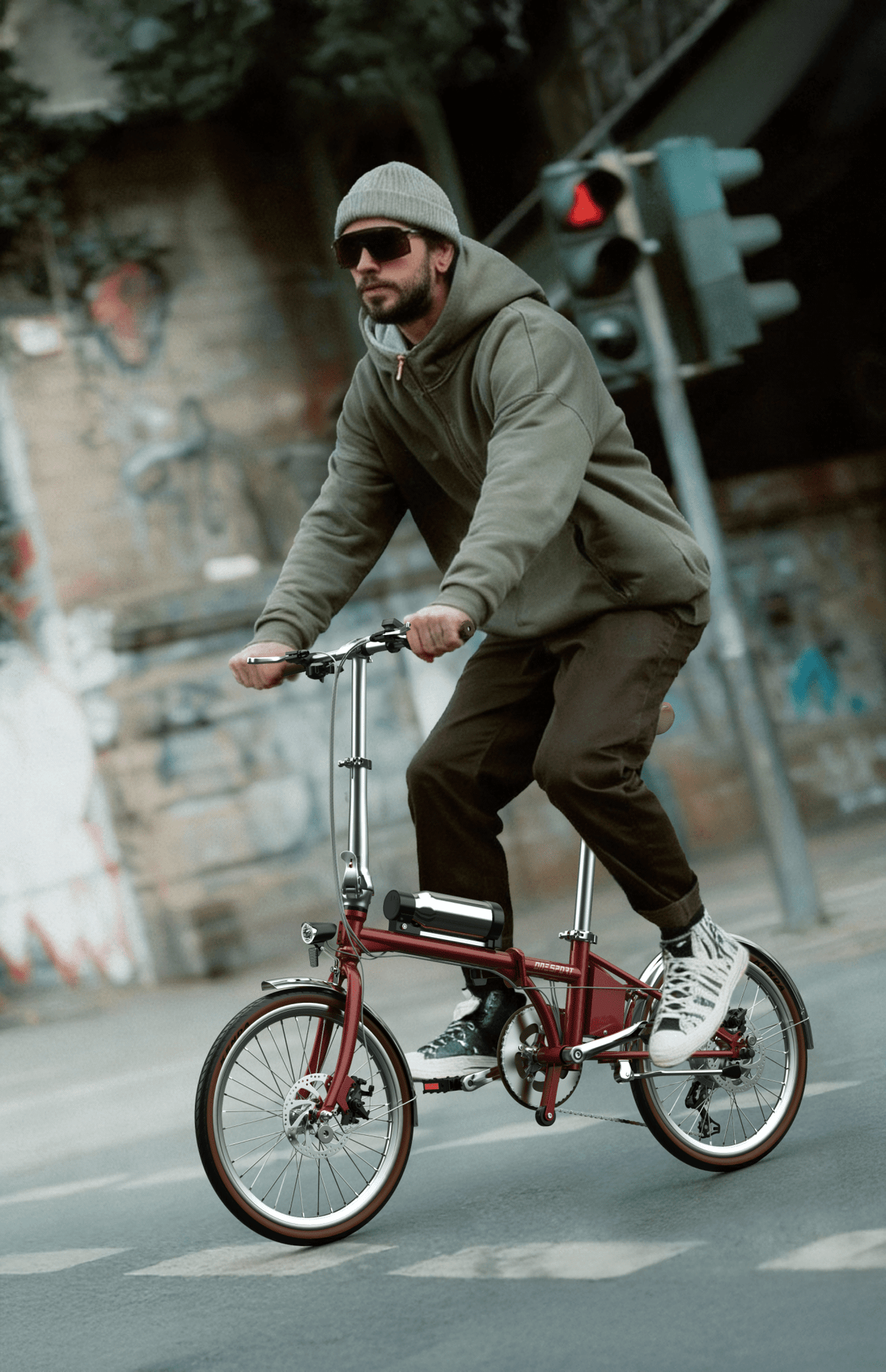 Man som kör OneSport OT02 Pro hopfällbar elcykel i färgen röd på en gata
