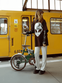 Kvinna står med OneSport OT02 Pro hopfällbar elcykel i färgen grön på en gata