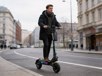Man som kör OOTD T10 Pro elsparkcykel i stadsmiljö