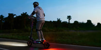 Person som kör OOTD T10 Pro elsparkcykel i solnedgång