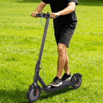 Man som kör SEEDREAM RED WING MINI elsparkcykel på en gräsplan