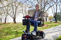 Man sitter på Sweetrich S1 Sport permobil i en park