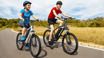 Två förare med VARUN M24-1 elmountainbike med hjälm på en väg