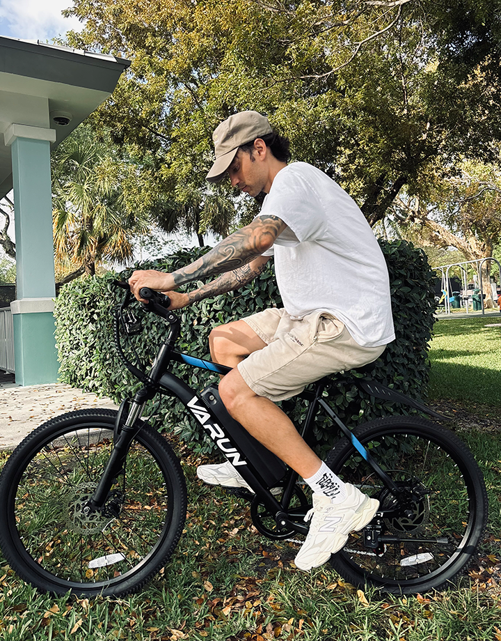 Man som kör VARUN M24-1 elmountainbike i färgen svart i en park